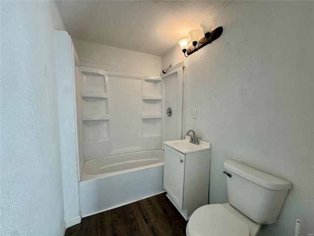 full bathroom featuring hardwood / wood-style floors, vanity, toilet, a textured ceiling, and washtub / shower combination