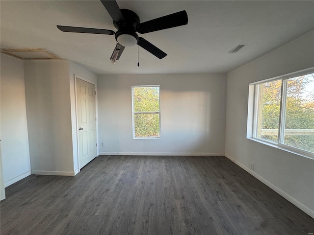 empty room featuring dark hardwood / wood-style flooring and a healthy amount of sunlight