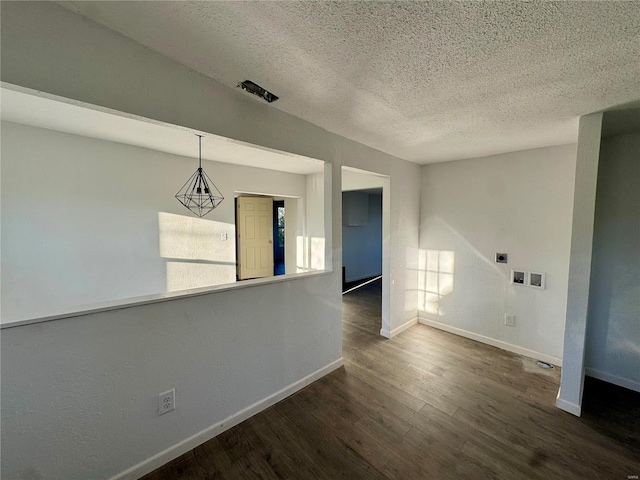 empty room with dark hardwood / wood-style floors and a textured ceiling