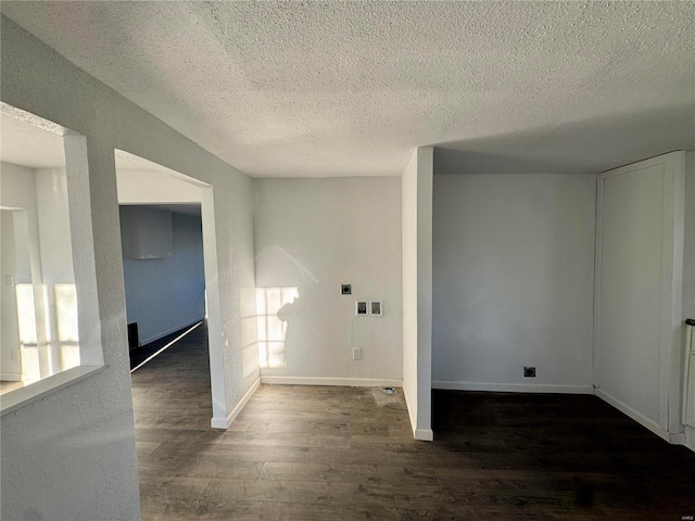 empty room with dark hardwood / wood-style floors and a textured ceiling