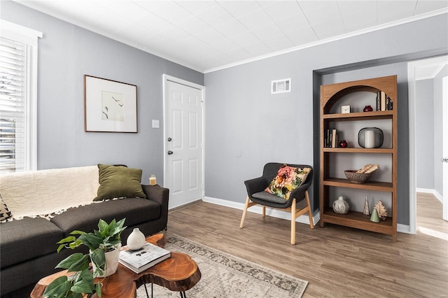 living room with crown molding and hardwood / wood-style floors