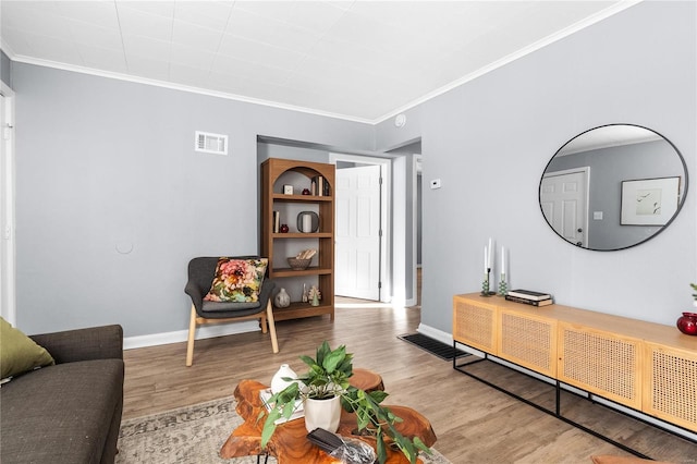 living room featuring light hardwood / wood-style flooring and ornamental molding