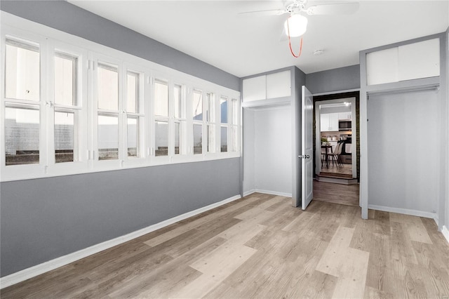 unfurnished bedroom featuring ceiling fan, a closet, and light wood-type flooring