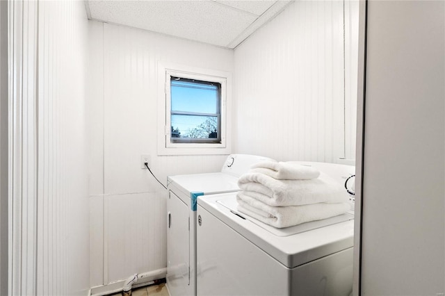 clothes washing area with wooden walls and washer and clothes dryer