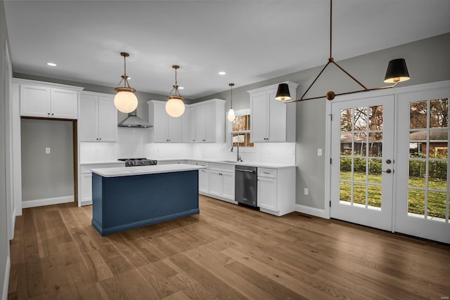 kitchen featuring a center island, hanging light fixtures, stainless steel appliances, wood-type flooring, and white cabinets