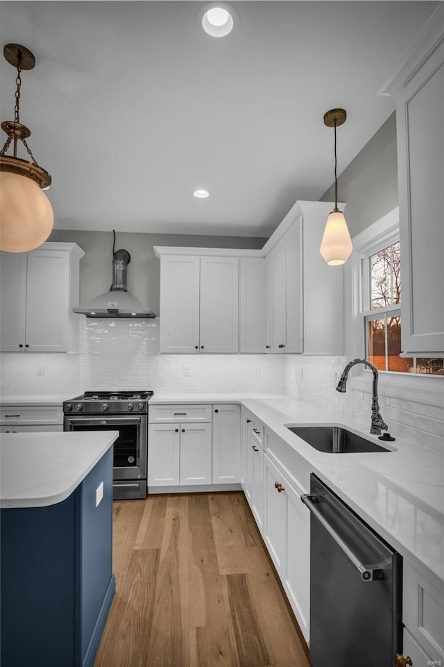 kitchen featuring pendant lighting, stainless steel appliances, white cabinetry, and sink