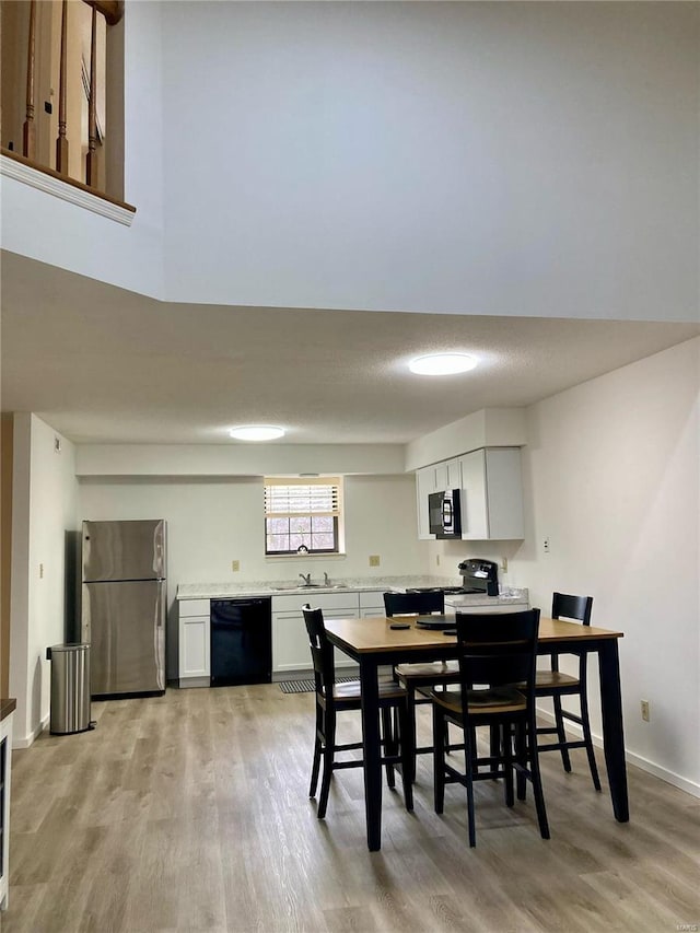 dining space with sink and light hardwood / wood-style flooring