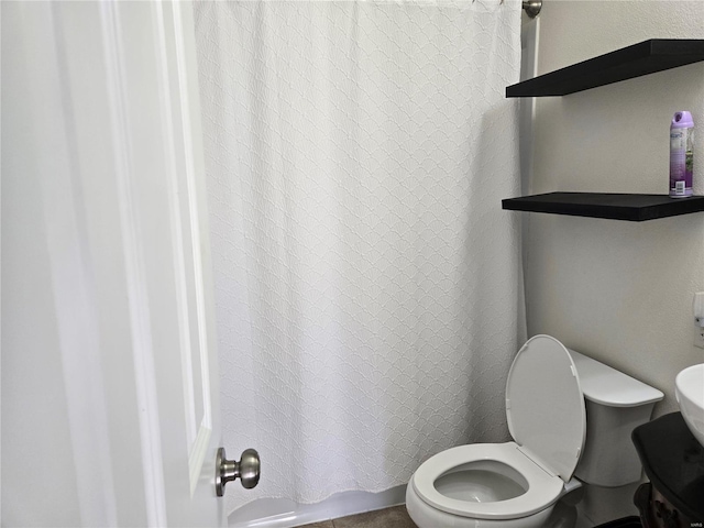 bathroom featuring curtained shower and toilet