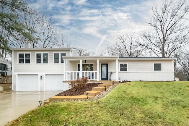 tri-level home featuring a porch, a garage, and a front yard