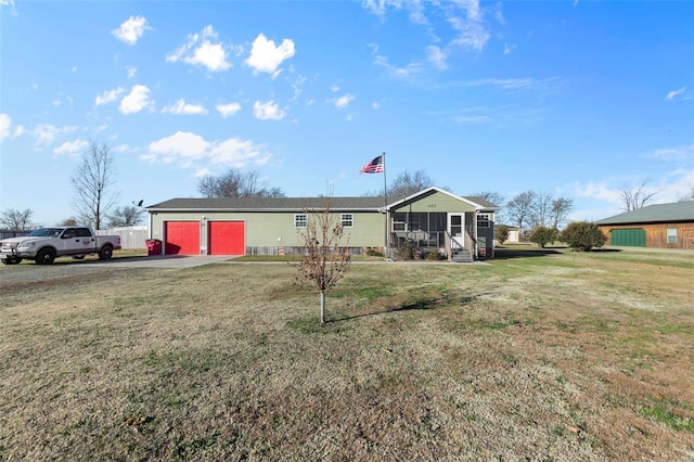 view of front of property with a sunroom, a front lawn, and a garage