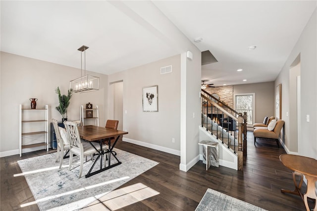 dining room featuring dark wood-type flooring and ceiling fan with notable chandelier