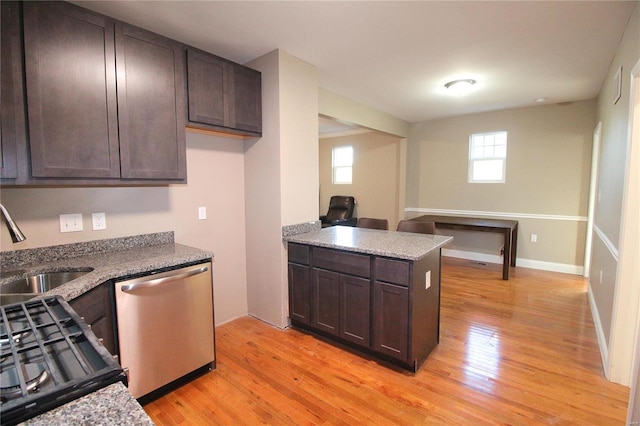 kitchen with light wood-type flooring, stainless steel dishwasher, and a wealth of natural light