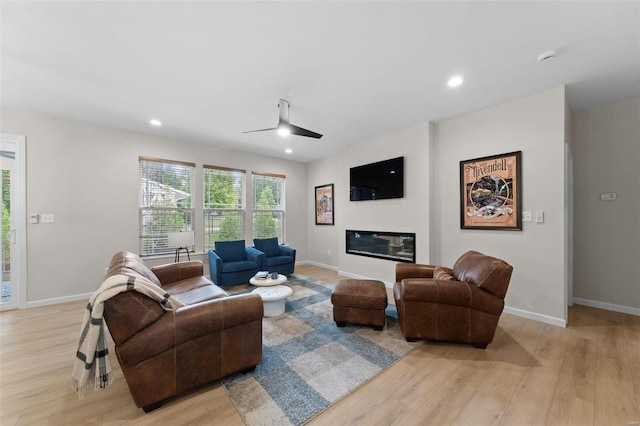 living room featuring ceiling fan and light hardwood / wood-style floors