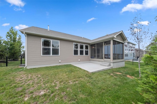 rear view of house featuring a lawn, a sunroom, and a patio