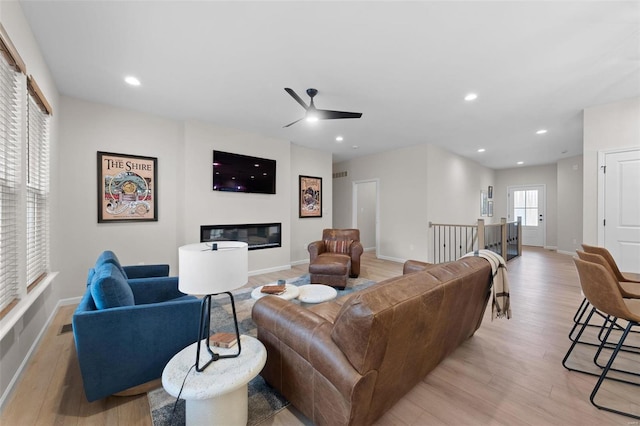 living room with ceiling fan and light wood-type flooring