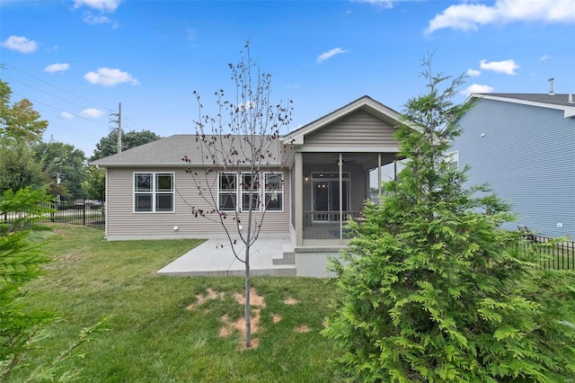 rear view of property featuring a yard, a patio area, a sunroom, and ceiling fan