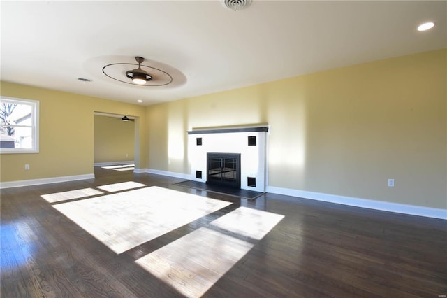 unfurnished living room with ceiling fan and dark wood-type flooring