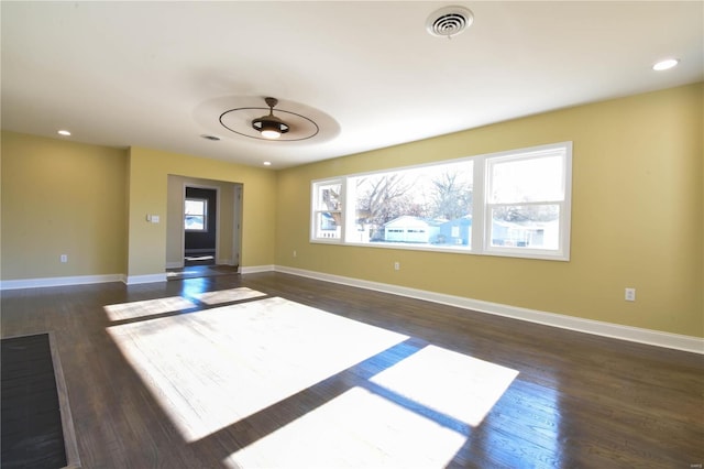 unfurnished living room with ceiling fan, plenty of natural light, and dark wood-type flooring