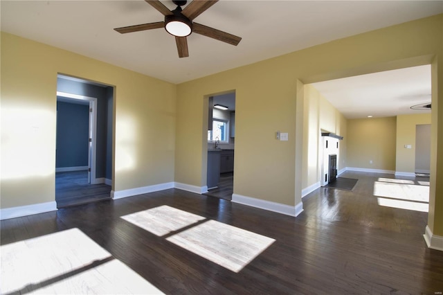 unfurnished room with ceiling fan, sink, and dark hardwood / wood-style floors