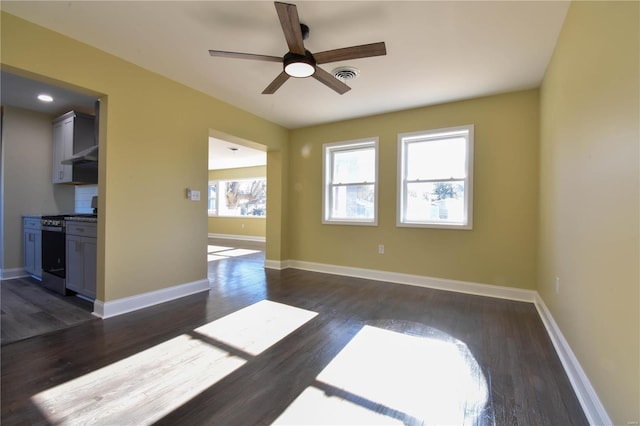 empty room with ceiling fan and dark wood-type flooring