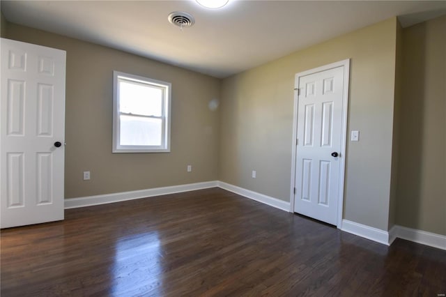 unfurnished room with dark hardwood / wood-style flooring