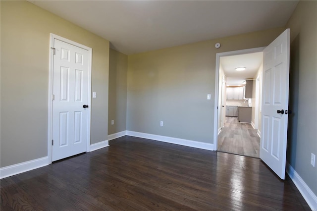 empty room featuring dark wood-type flooring and sink