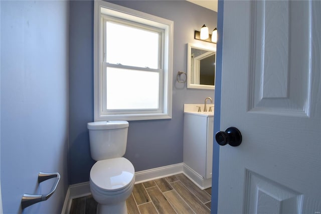 bathroom featuring plenty of natural light, vanity, hardwood / wood-style floors, and toilet