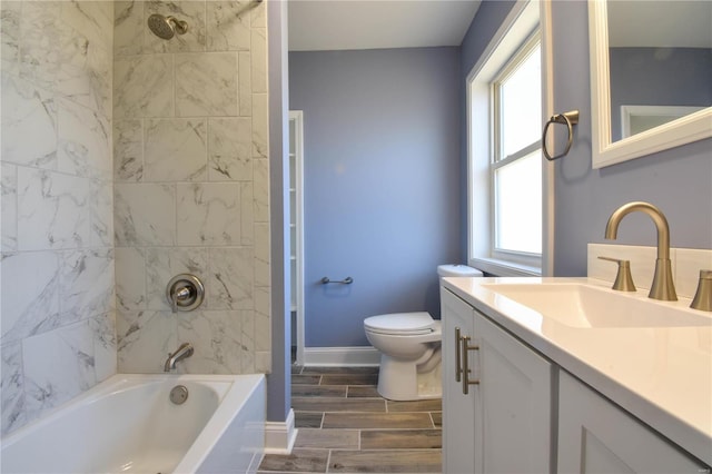 full bathroom featuring vanity, toilet, tiled shower / bath, and a wealth of natural light