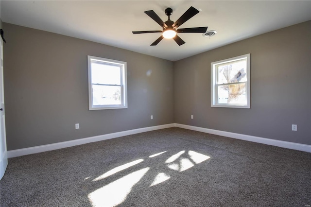 carpeted spare room featuring ceiling fan and a healthy amount of sunlight