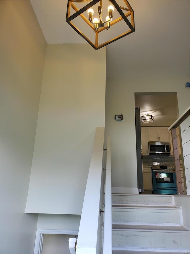 staircase with an inviting chandelier