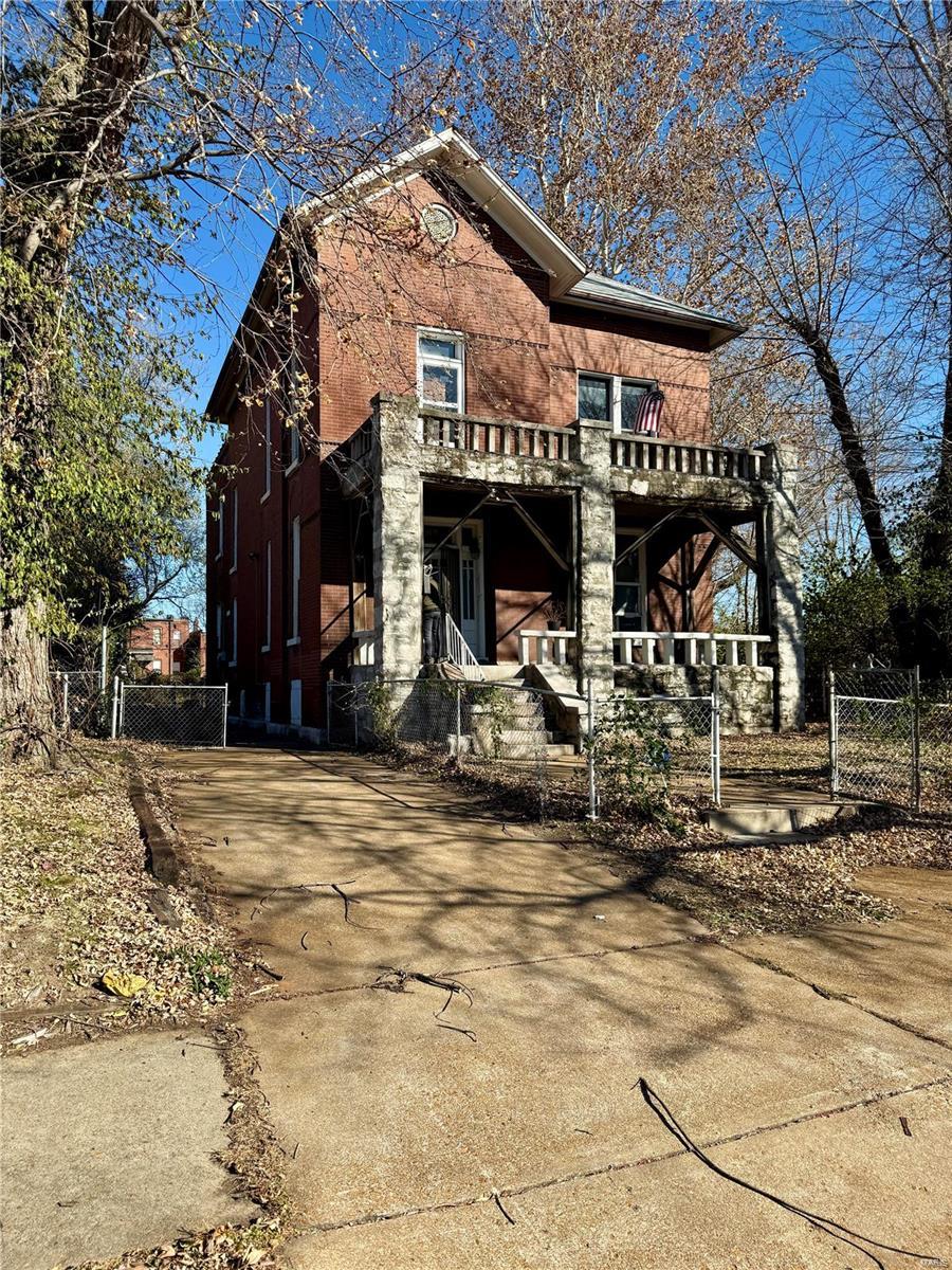 rear view of property featuring covered porch