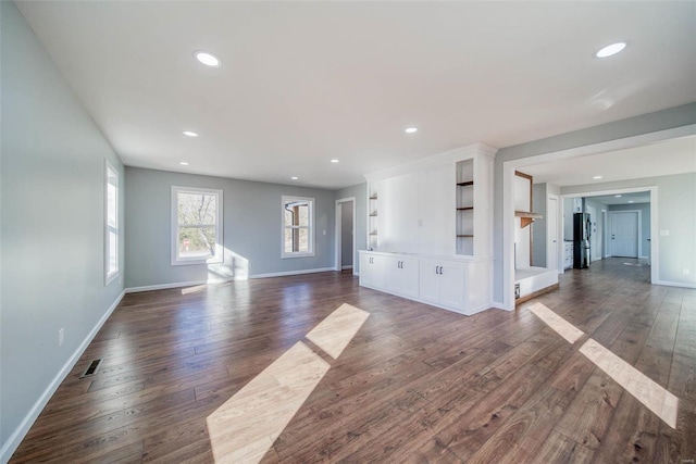 unfurnished living room featuring dark wood-type flooring