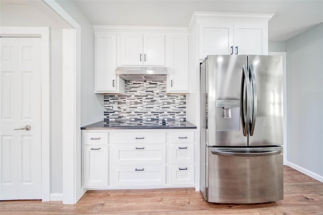 kitchen with backsplash, exhaust hood, stainless steel refrigerator with ice dispenser, light hardwood / wood-style floors, and white cabinetry