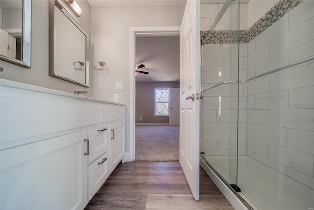 bathroom with hardwood / wood-style floors, walk in shower, and ceiling fan