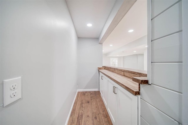 bar featuring white cabinets, light wood-type flooring, and wood counters