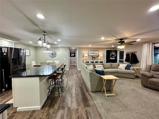 living room with ceiling fan and dark hardwood / wood-style flooring