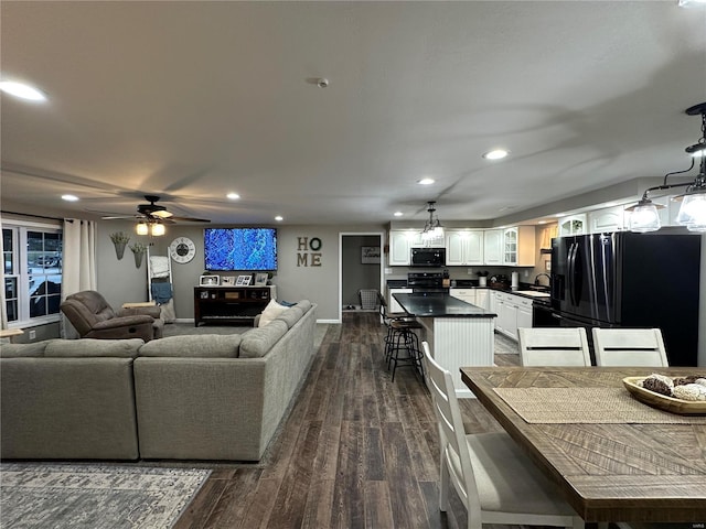 living room with dark hardwood / wood-style floors, ceiling fan, and sink