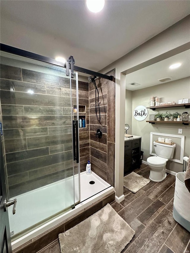 bathroom with vanity, an enclosed shower, and toilet