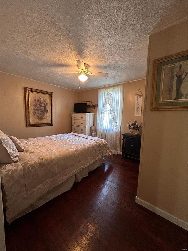 bedroom featuring ceiling fan, dark wood-type flooring, and a textured ceiling