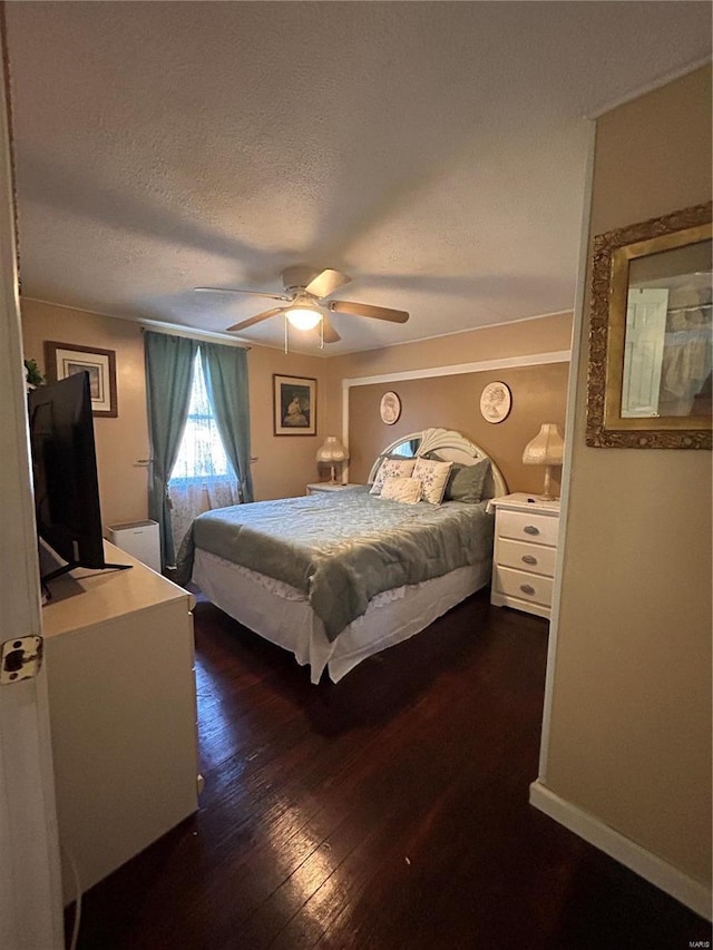 bedroom featuring ceiling fan, dark wood-type flooring, and a textured ceiling