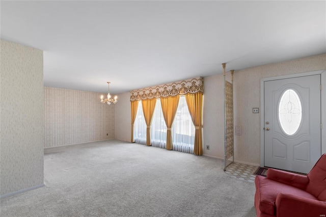 foyer entrance with a chandelier, carpet floors, and a healthy amount of sunlight