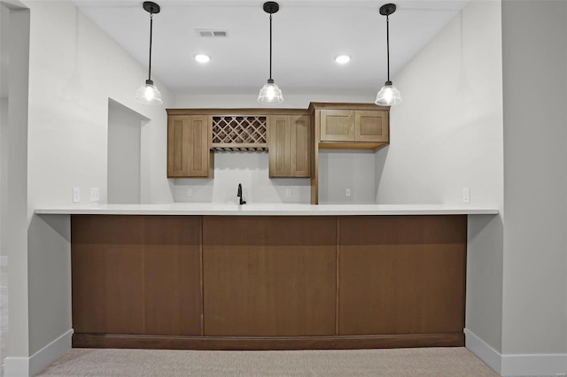 bar with pendant lighting, light colored carpet, and sink