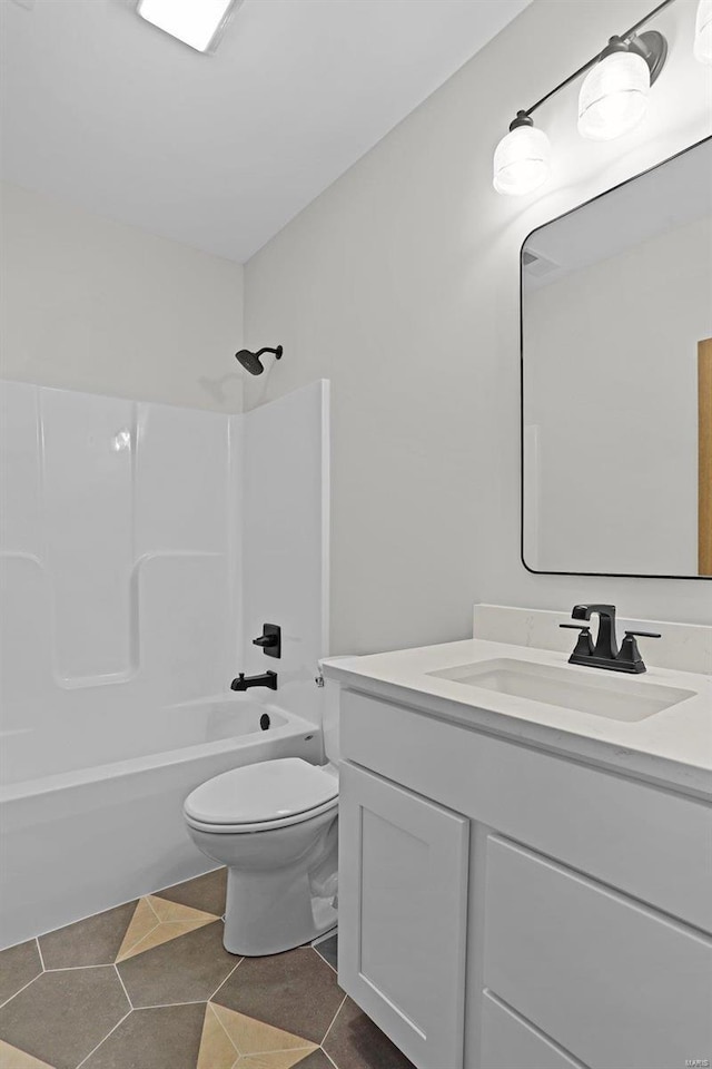 full bathroom featuring toilet, vanity, tile patterned floors, and shower / washtub combination