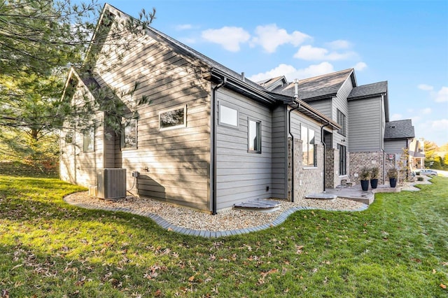 view of property exterior with a lawn and central AC