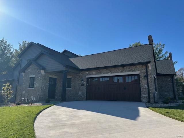 view of front of property featuring a garage and a front lawn