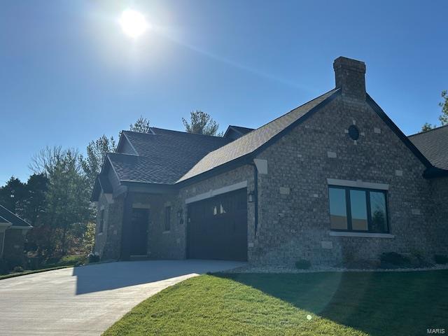 view of front of home with a front lawn and a garage