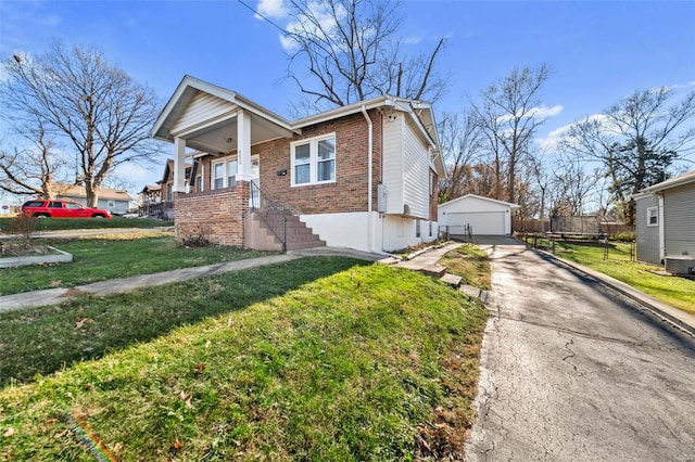 view of front of home featuring a garage, a front lawn, and an outdoor structure