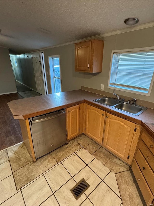 kitchen with sink, stainless steel dishwasher, kitchen peninsula, a textured ceiling, and ornamental molding