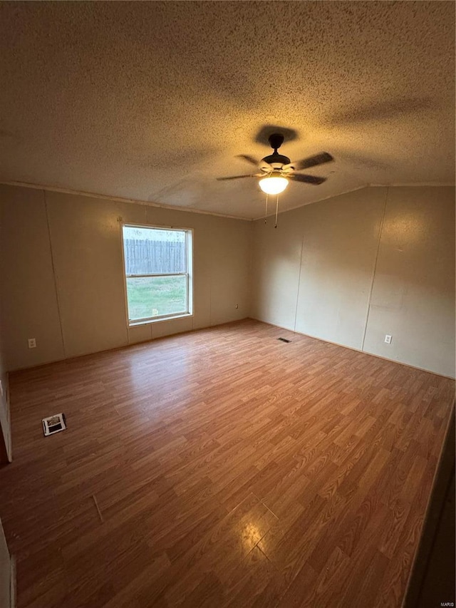 spare room featuring a textured ceiling, hardwood / wood-style flooring, and ceiling fan