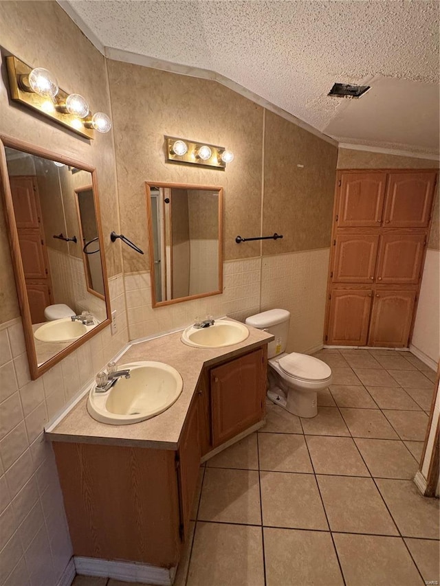 bathroom featuring tile patterned flooring, a textured ceiling, vaulted ceiling, and tile walls